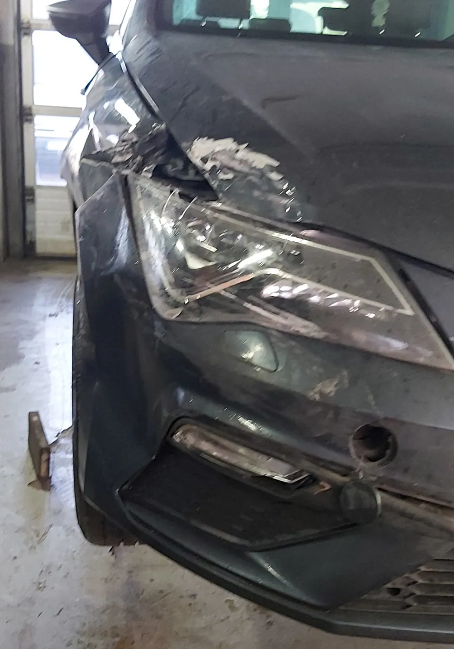 Unfallfahrzeug mit beschädigtem Kotflügel und Scheinwerfer